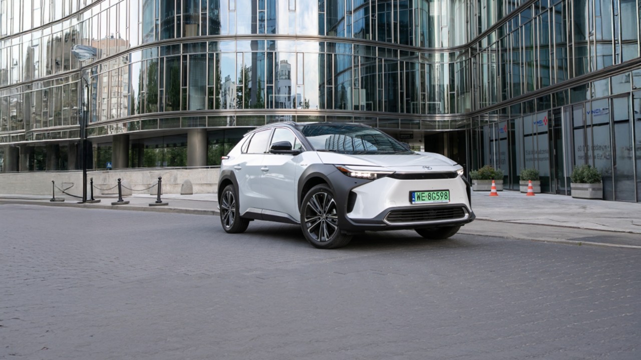 Toyota bZ4X zaparkowana na tle szklanego budynku